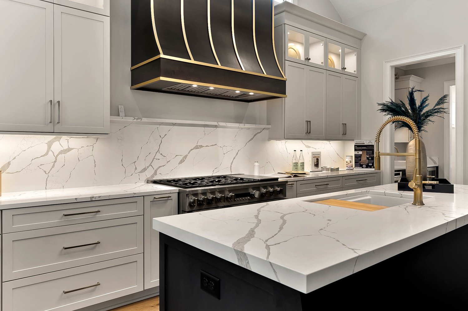 Luxury kitchen with black and gold range hood and marble countertops, professionally photographed by R. Huggins in Raleigh, NC
